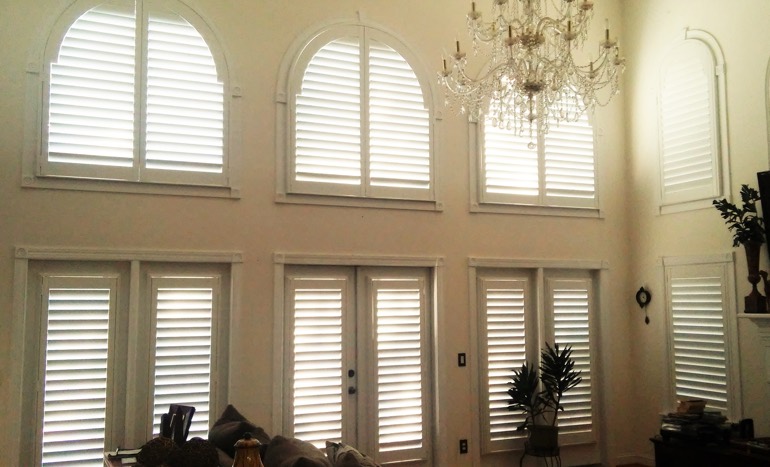 TV room in two-story Raleigh house with plantation shutters on tall windows.