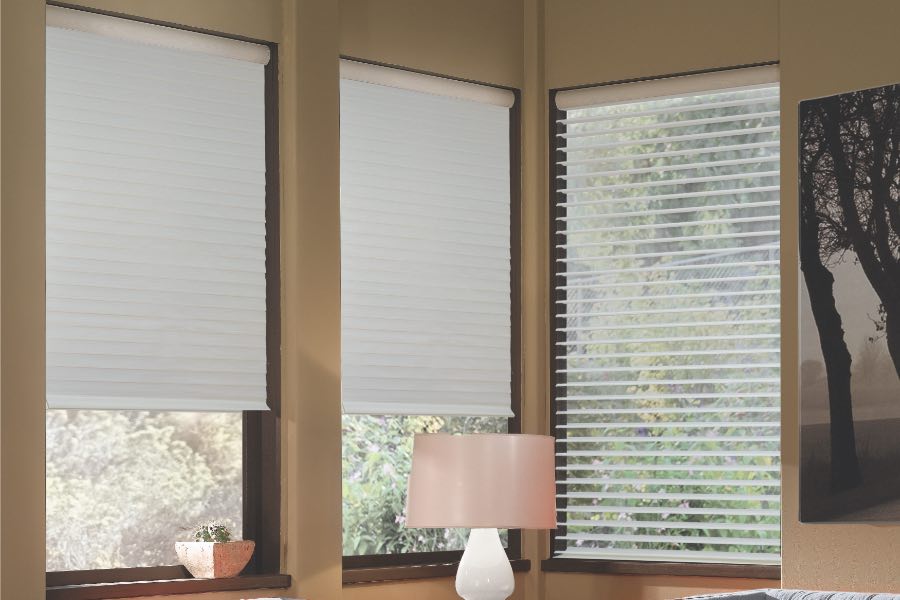 Opaque motorized window shades in Raleigh keep hot UV rays out of your home. Gray motorized sheer shades on corner windows next to gray furniture