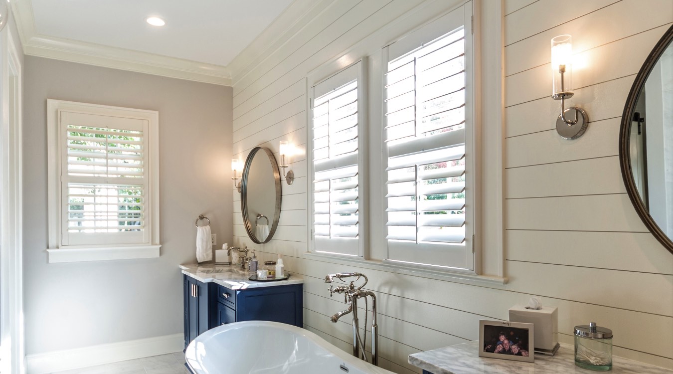 Raleigh bathroom with white plantation shutters.