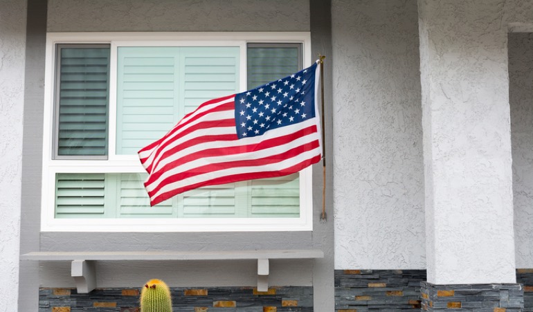 Alt Text: American flag flying in front of a home