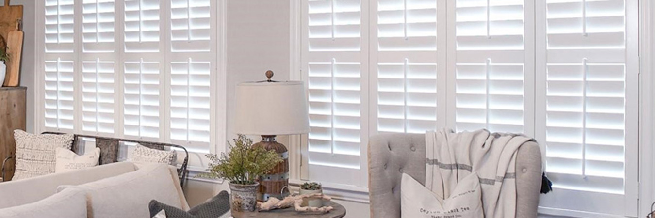 White polywood shutters in an open concept kitchen and living room area