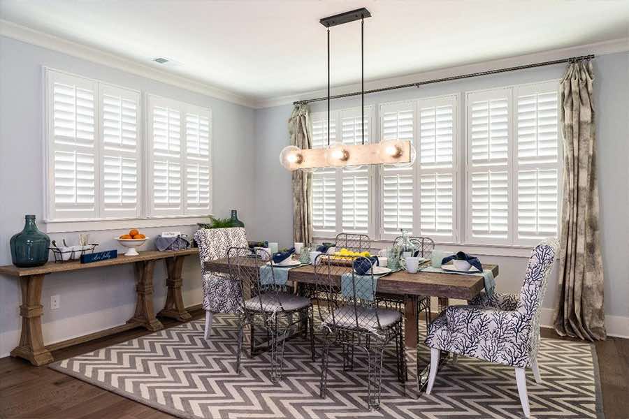 Energy-efficient Polywood shutters keep your home comfortable and energy bills affordable all year long. White Polywood shutters on large dining room windows