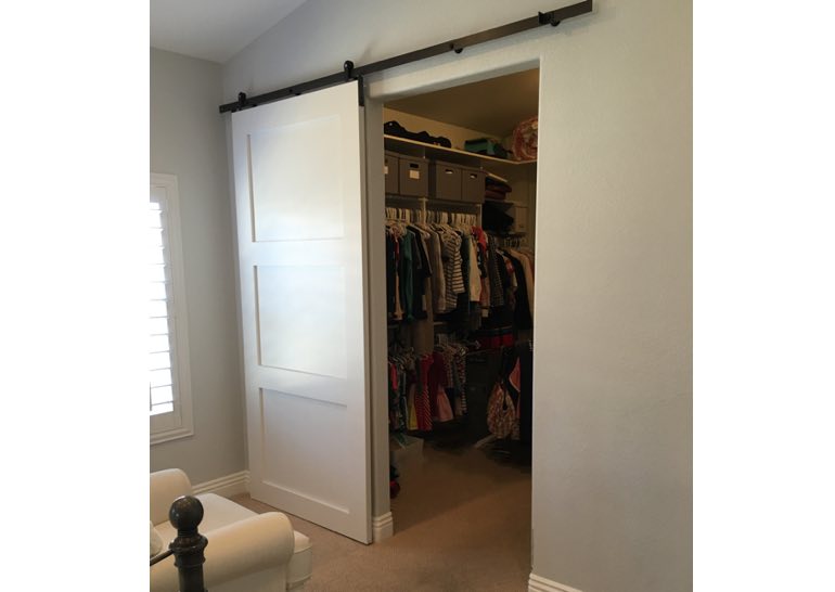 White sliding barn door covering closet