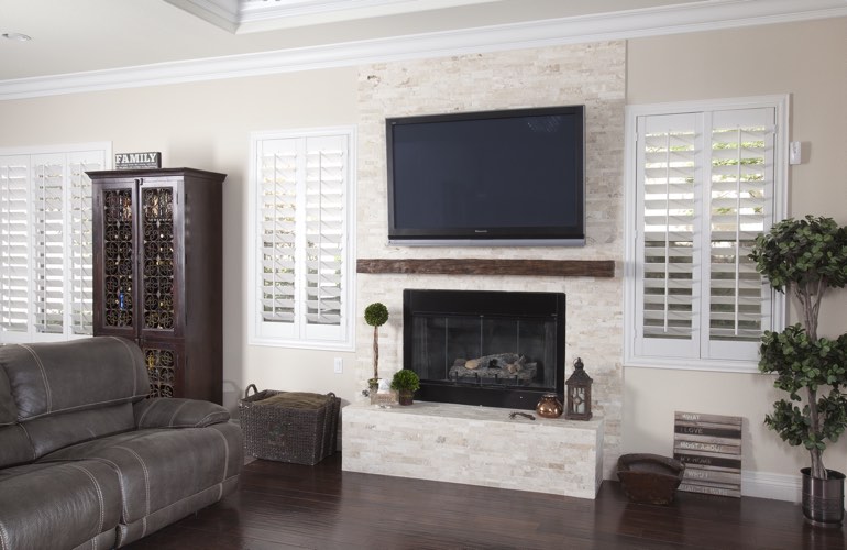White plantation shutters in a Raleigh living room with plank hardwood floors. White plantation shutters in a Raleigh living room with plank hardwood floors.