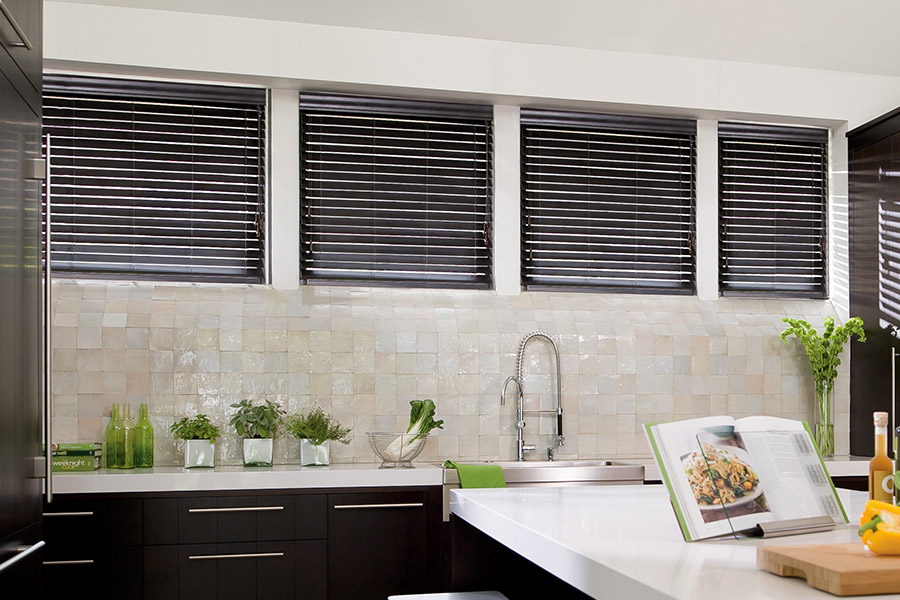 Choose custom Polywood faux wood blinds for your kitchen in Raleigh. Special shaped faux wood blinds in several windows above a sink.