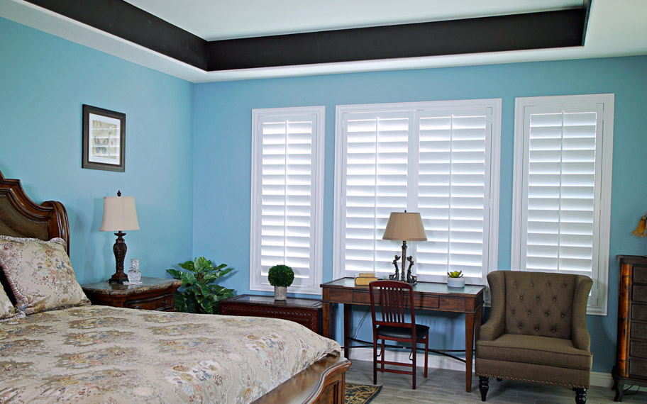 Polywood shutters provide insulation for the perfect temperature all year long in Raleigh. Polywood shutters in a bedroom.