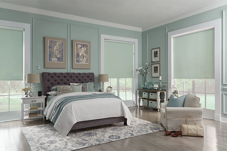 Find roller shades in colors that match, complement, or contrast with your home's color palette. Light green roller shades on windows in a green bedroom
