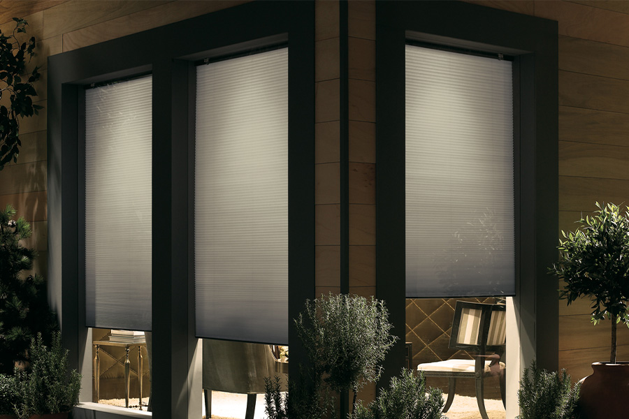 Cellular shades are modern and stylish window treatments for your home in Raleigh. Dark gray cellular shades displayed from the exterior of a home.