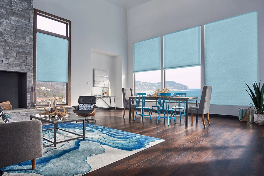 Blue motorized shades on tall living room windows