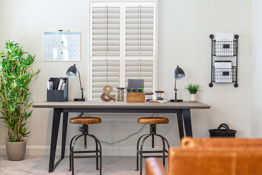 Don't let heat or cold distract you from work. Install energy-efficient Polywood shutters in your home office. White Polywood shutters on a home office window